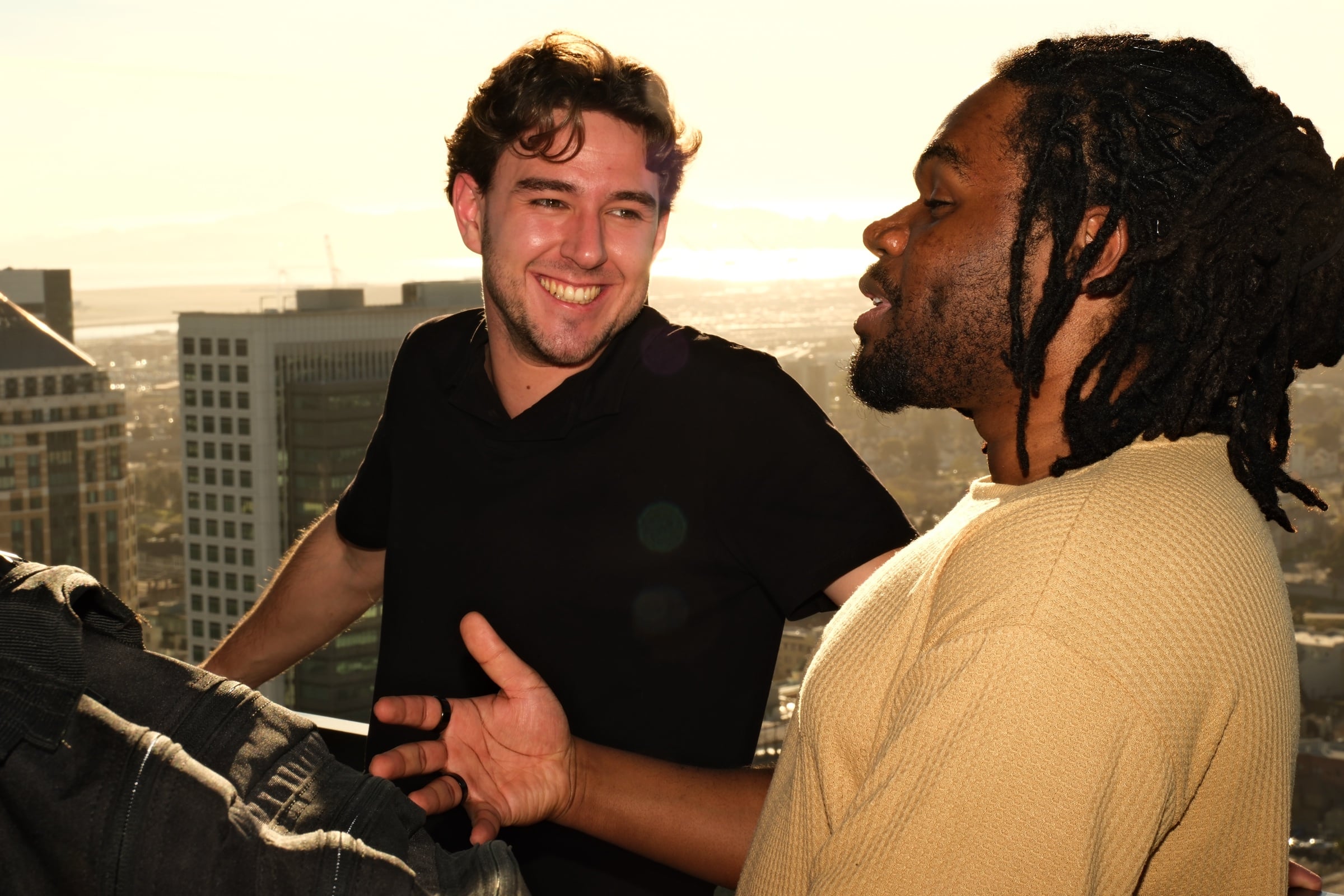 Participants talking on the rooftop with the city skyline behind them