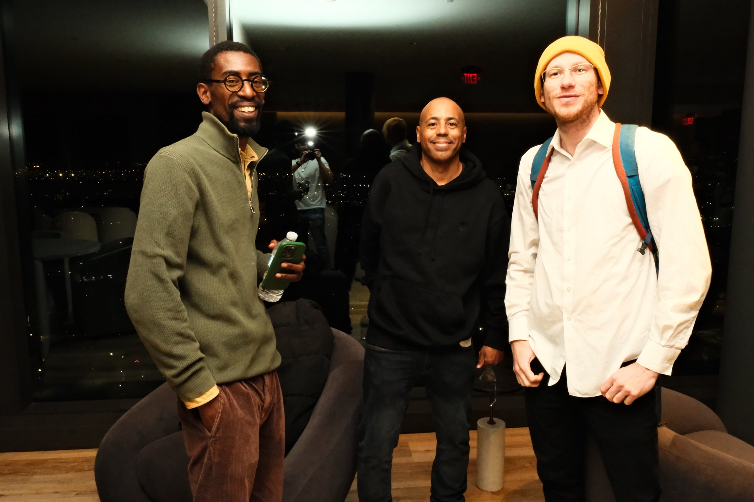 Three attendees together inside the penthouse at night