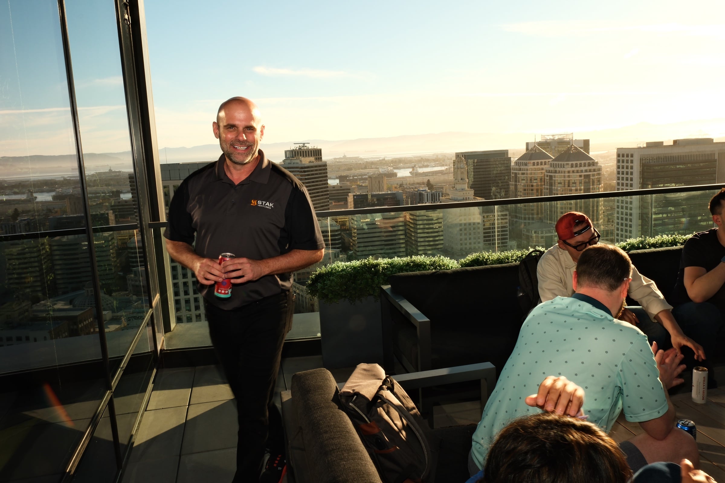 STAK rooftop at golden hour, Oakland skyline panorama with the Bay in the background